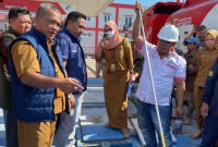 Ahmad Dony Evriady saat melakukan pemeriksaan menggunakan besi panjang yang diolesi pasta air dalam tangki mobil bermuatan 8.000 liter Pertalite (*/MMP)