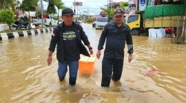 Ketua AJKT Sukriadi didampingi Anggota Firdauz tampak sedang mendistribusikan bantuan makanan di tengah banjir Sangatta, Senin (21/3/2022). (foto: AJKT)