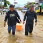 Ketua AJKT Sukriadi didampingi Anggota Firdauz tampak sedang mendistribusikan bantuan makanan di tengah banjir Sangatta, Senin (21/3/2022). (foto: AJKT)