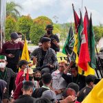 Sangattaku.com - Bawa 11 tuntutan, Aliansi Rakyat Kutim Bergerak geruduk Kantor DPRD Kutai Timur (Kutim). Sekelompok mahasiswa yang mengatasnamakan Aliansi Rakyat Kutim Bergerak, Senin (11/04/2022) menggelar aksi unjuk rasa di depan Gedung Kantor DPRD Kutim. Mengawali aksi, dengan membawa atribut organisasi dan poster bertuliskan kritikan atas kinerja pemerintahan Jokowi-Ma'ruf, mahasiswa menggelar longmarch yang berujung di depan Kantor DPRD Kutim. Dalam aksinya, para mahasiswa bawa 11 tuntutan, satu di antaranya yakni terkait isu penundaan pemilu. Mereka menolak keras penundaan pemilu 2024 serta perpanjangan masa jabatan Jokowi hingga 3 periode seperti isu yang telah beredar. “Kami mengutuk keras kepada pemerintah untuk melepaskan isu dari sejumlah menteri dan parpol terkait perpanjangan tiga periode,” ucap Gilardino, koordinator lapangan. Tak hanya Gilardino, di titik aksi, dengan penjagaan puluhan aparat kepolisian yang mengawal jalannya aksi, secara bergantian para mahasiswa pun berorasi. Selain isu penundaan pemilu, mahasiswa juga menolak adanya kenaikan bahan pokok maupun kenaikan BBM (Bahan Bakar Minyak). Bawa 11 Tuntutan, Berikut Daftar Lengkap Tuntutan Aliansi Rakyat Kutim Bergerak Berikut tuntutan lengkap mahasiswa yang tergabung dalam Aliansi Rakyat Kutim Bergerak. Menolak dengan tegas perpanjangan masa jabatan Presiden Republik Indonesia, dan penundaan pelaksanaan pemilihan umum 2024. Menolak serta segera batalkan kenaikan PPn 11%, BBM dan usut tuntas penyebab kelangkaan pertalite serta solar. Segera sahkan RUU PKS tanpa dipreteli, dan RUU Masyarakat Hukum Adat. Wujudkan keadilan, dan kebebasan dalam perguruan tinggi di Kabupaten Kutai Timur. Mendesak Pemerintah Kabupaten Kutai Timur sesegera mungkin memaksimalkan reformasi birokrasi demi meningkatkan kualitas, dan inovasi pelayanan publik. Pemerintah Kabupaten Kutai Timur harus memprioritaskan, dan mendukung sektor pertanian dalam menciptakan produktivitas, komoditas unggulan berlandaskan agribisnis-agroindustri, hingga ketahanan pangan yang memadai. Mendorong Pemerintah Kabupaten Kutai Timur melakukan investigasi ke industri ekstraktif yang diduga melakukan pelanggaran lingkungan. Pemerintah Kabupaten Kutai Timur secepatnya menyelesaikan produk hukum ketenagakerjaan secara partisipatif, yang melibatkan seluruh lapisan angkatan kerja. Mendesak Pemerintah Kabupaten Kutai Timur mencabut Izin Usaha Toko Modern yang melanggar peraturan kepala daerah. Menuntut pemerintah agar memulihkan hak-hak korban banjir, serta menyusun rencana penanggulangan bencana hingga deklarasikan darurat iklim di Kabupaten Kutai Timur. Investigasi praktik kartel, dan penyebab utama terjadinya kelangkaan minyak goreng di Kabupaten Kutai Timur. Sejauh pantauan Sangattaku.com, aksi berjalan cukup lancar dan kondusif.(*/bl)