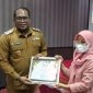 Wakil Bupati Kutai Timur, Kasmidi Bulang menyerahkan Piagam kepada Uwwu.(foto:/istimew)