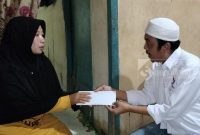 Bendahara DPD Perindo Kutai Timur, Ari Martono saat menyerahkan bantuan kepada Ibunda Yoga, Jatmiyati (16/03). (bl/sangattaku)