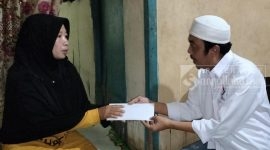 Bendahara DPD Perindo Kutai Timur, Ari Martono saat menyerahkan bantuan kepada Ibunda Yoga, Jatmiyati (16/03). (bl/sangattaku)